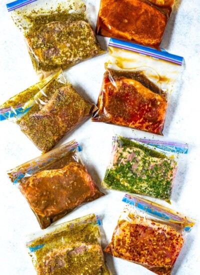 8 different freezer bags, each containing a different kind of marinated steak.