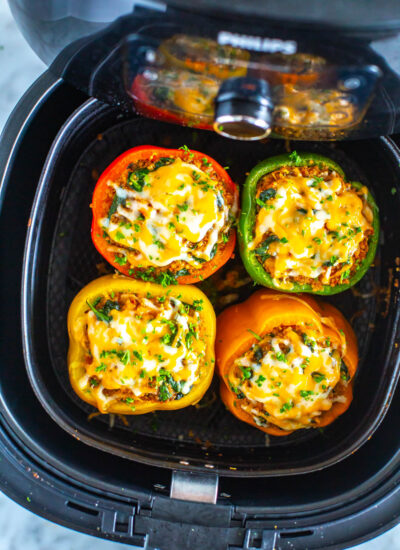 Four cooked air fryer stuffed peppers in an air fryer.