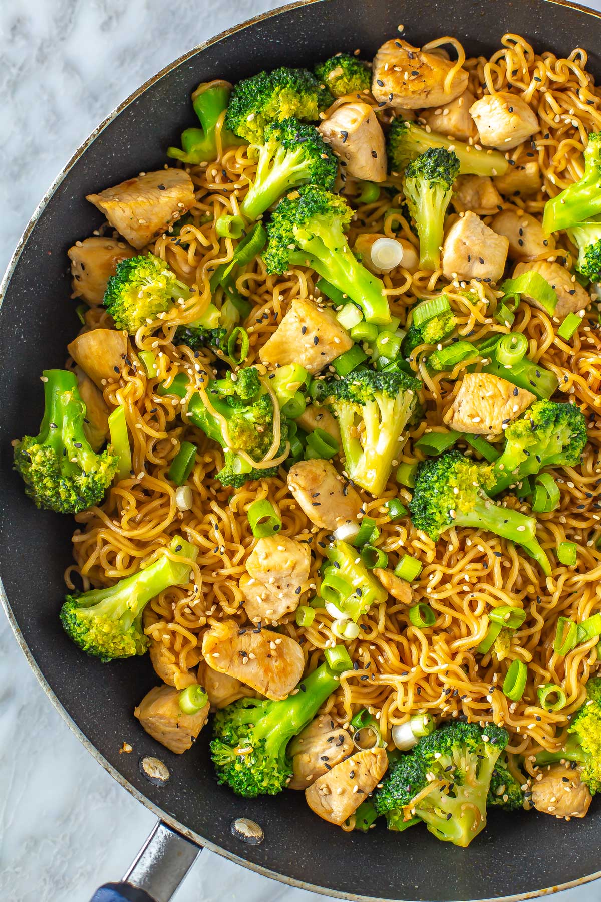 A close-up of a skillet filled with chicken ramen stir fry.