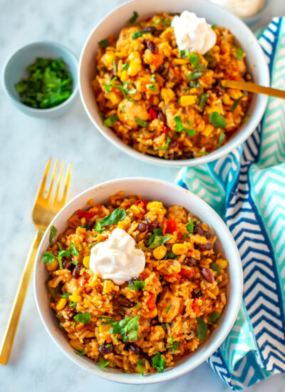 Two Instant Pot chicken burrito bowls topped with sour cream.