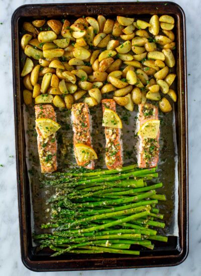 A sheet pan with roasted salmon, potatoes and asparagus.