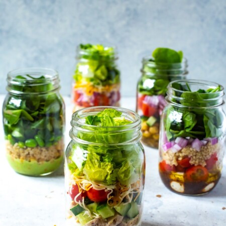 A close-up of the ranch mason jar salad, with the other mason jar salads in the background.