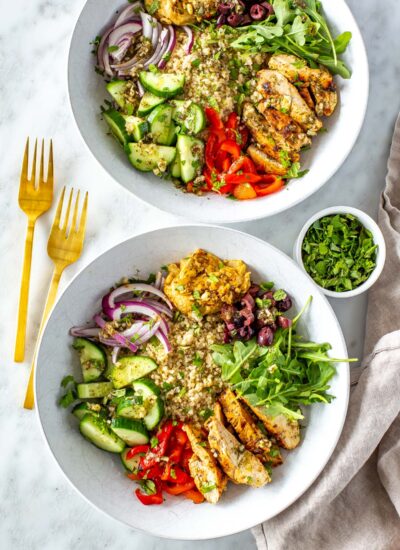 Two Mediterranean bowls topped with parsley.