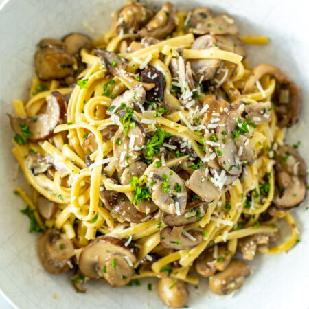 A close-up of a bowl of creamy mushroom pasta.