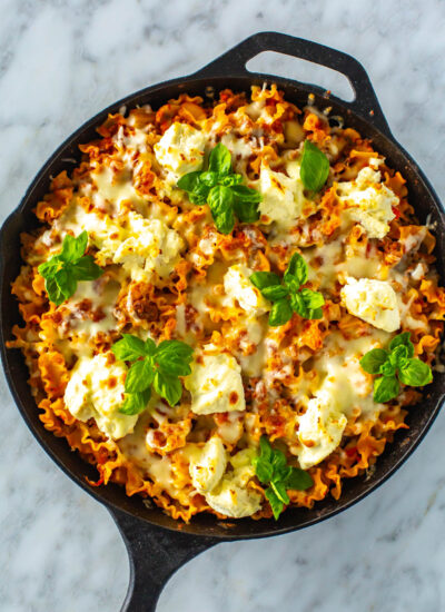 An overhead shot of skillet lasagna garnished with fresh basil.