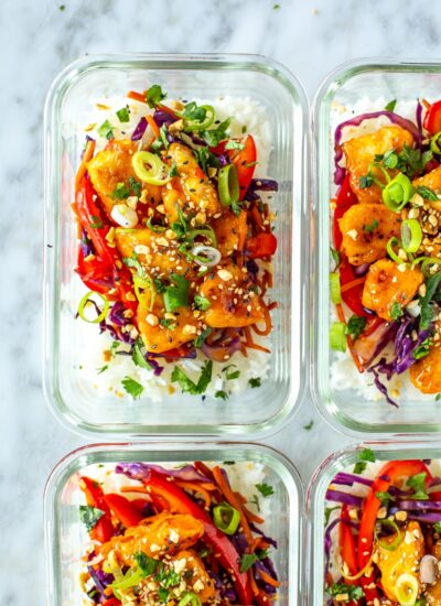 Four meal prep containers with sweet chili chicken inside.