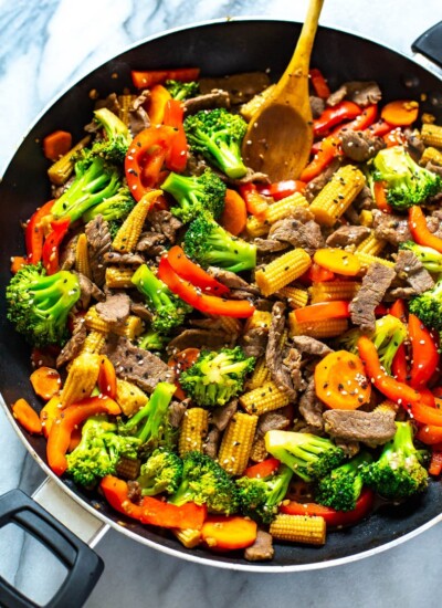 Beef stir fry in a black skillet.