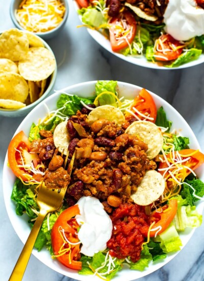 A close-up of a bowl of Copycat Wendy's Taco Salad with a fork in it.